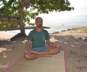 homem meditando na praia macaé